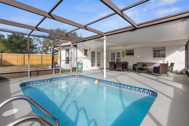 view of pool featuring a lanai, a patio area, an outdoor living space, and french doors