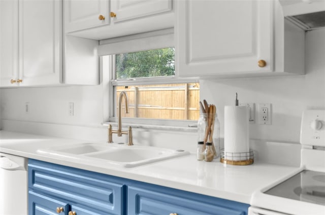 kitchen with dishwasher, range, blue cabinets, sink, and white cabinetry