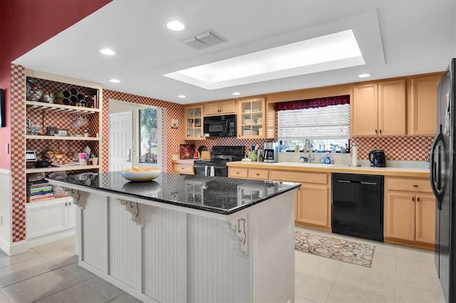 kitchen with a kitchen breakfast bar, sink, a healthy amount of sunlight, and black appliances