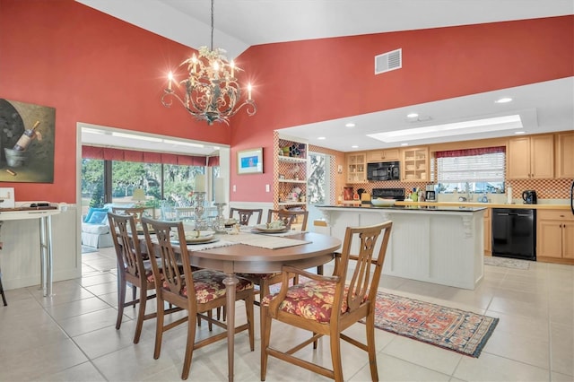 dining space featuring a healthy amount of sunlight, light tile patterned floors, high vaulted ceiling, and an inviting chandelier