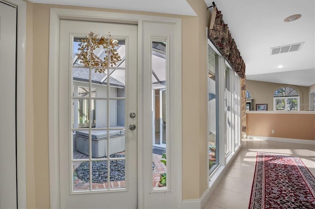 entryway featuring light tile patterned flooring and vaulted ceiling