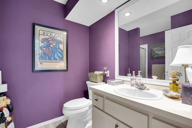 bathroom with hardwood / wood-style floors, vanity, and toilet