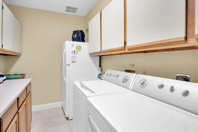 washroom with cabinets, light tile patterned floors, and washing machine and clothes dryer