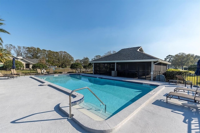 view of swimming pool featuring a patio and a sunroom