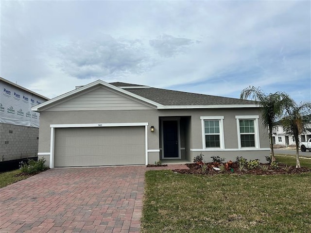 single story home featuring a front lawn and a garage