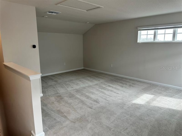 carpeted empty room featuring lofted ceiling