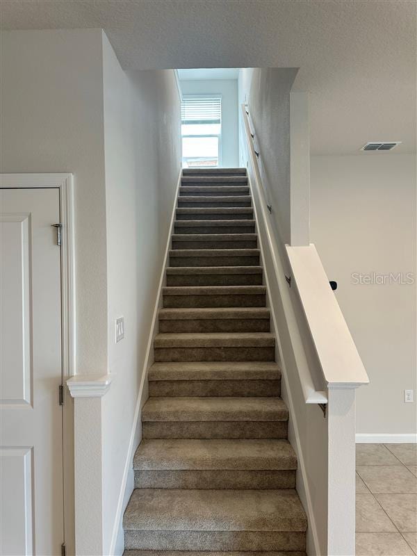 stairway with tile patterned floors