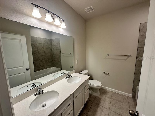 bathroom with toilet, vanity, and tile patterned flooring