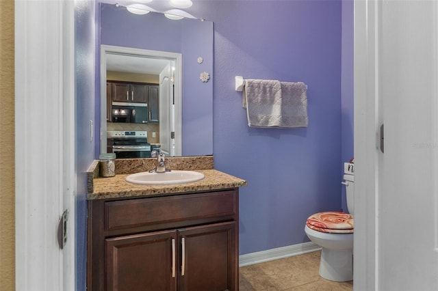 bathroom with decorative backsplash, vanity, toilet, and tile patterned flooring