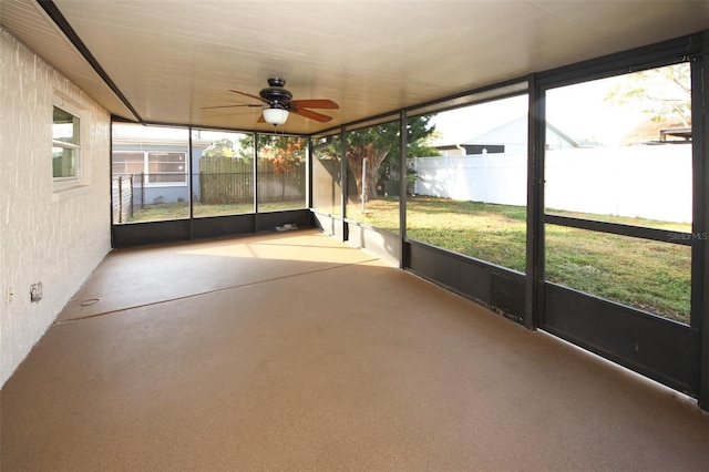 unfurnished sunroom featuring ceiling fan and a wealth of natural light