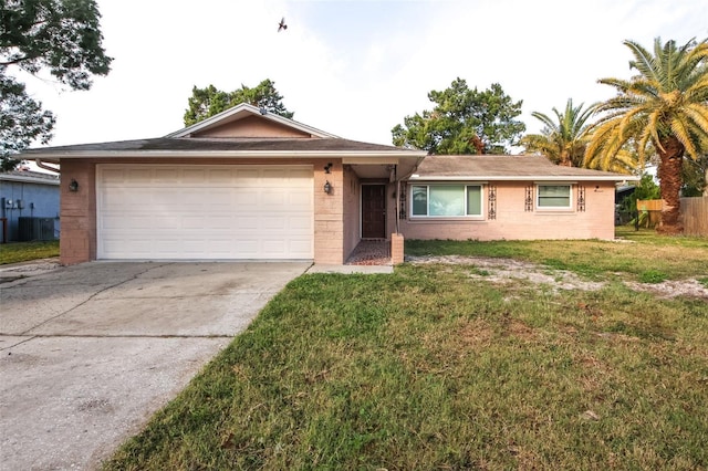 ranch-style home featuring a garage and a front lawn