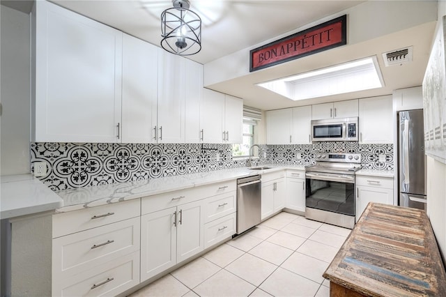 kitchen with white cabinetry, light tile patterned floors, and appliances with stainless steel finishes