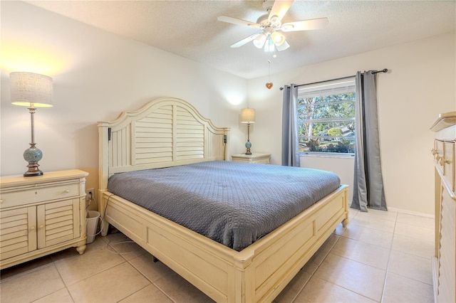 tiled bedroom featuring ceiling fan and a textured ceiling