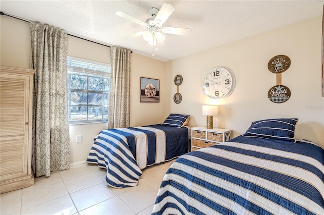 tiled bedroom featuring ceiling fan and a textured ceiling