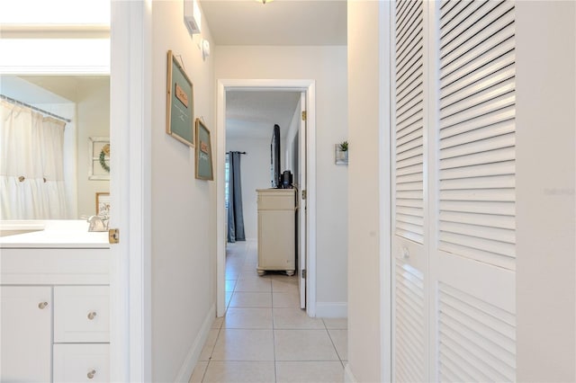 hallway with light tile patterned flooring and sink