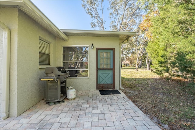 view of exterior entry featuring a patio area