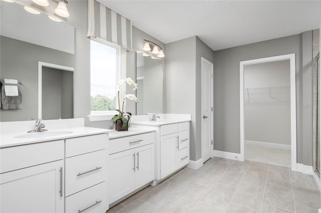 bathroom featuring tile patterned flooring, vanity, and a shower with shower door