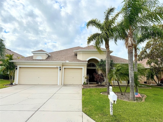 mediterranean / spanish-style house featuring a front yard and a garage