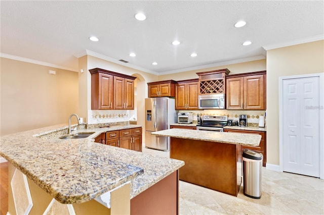 kitchen featuring kitchen peninsula, appliances with stainless steel finishes, light stone counters, and sink