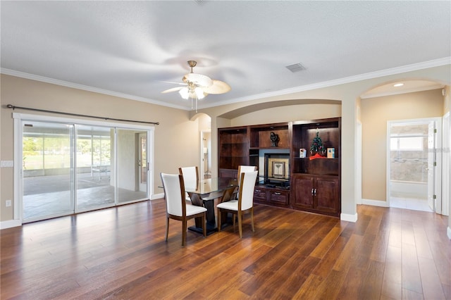 dining area featuring dark wood-type flooring, ceiling fan, and ornamental molding