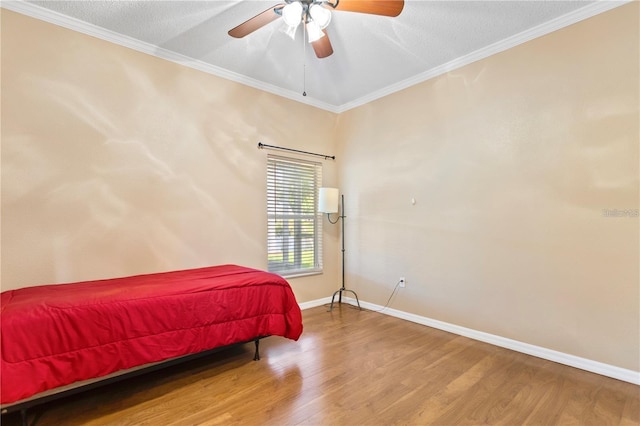 bedroom featuring ceiling fan, hardwood / wood-style floors, a textured ceiling, and ornamental molding