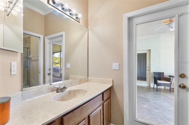 bathroom featuring vanity, ceiling fan, ornamental molding, and a shower with shower door