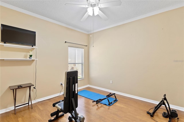 workout room with hardwood / wood-style flooring, ceiling fan, ornamental molding, and a textured ceiling