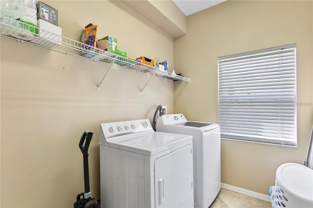 washroom featuring washer and clothes dryer and light tile patterned flooring