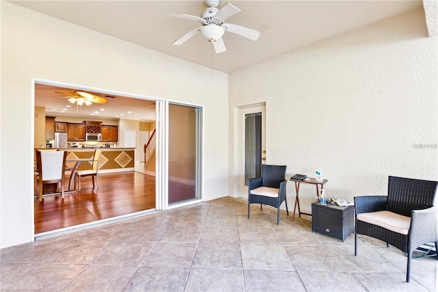 sitting room featuring ceiling fan and light tile patterned floors