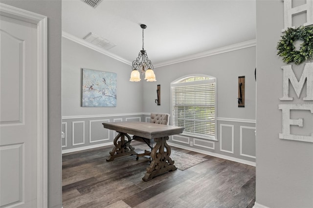 dining area featuring dark wood-type flooring, a chandelier, and crown molding