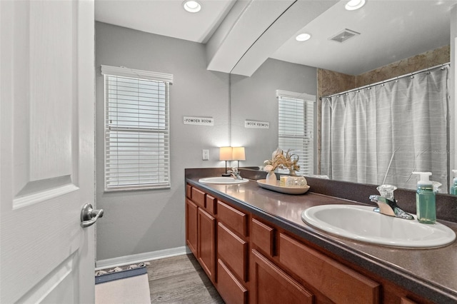 bathroom featuring wood-type flooring, walk in shower, and vanity