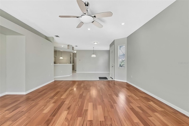 unfurnished living room with wood-type flooring and ceiling fan