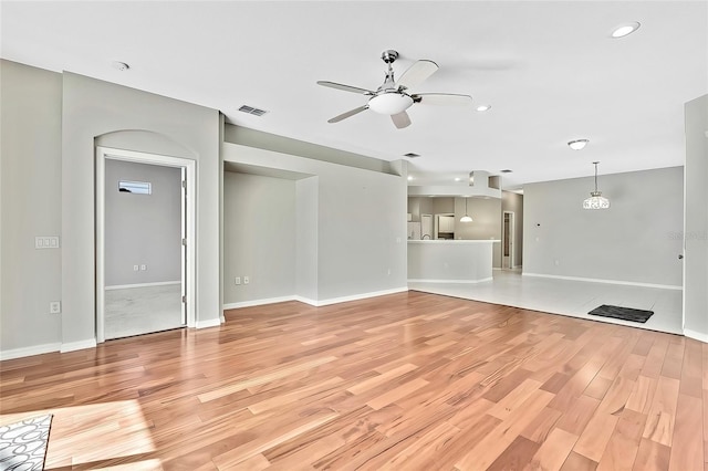 unfurnished living room with ceiling fan and light hardwood / wood-style floors