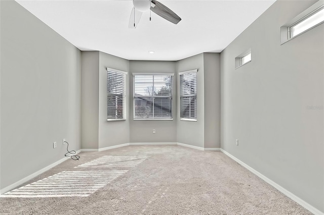 spare room with ceiling fan and light colored carpet