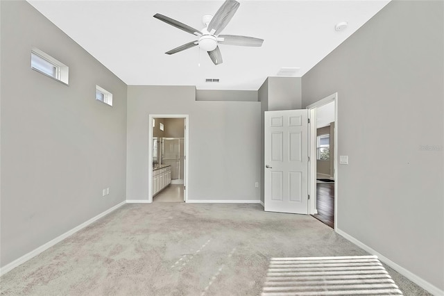 unfurnished bedroom featuring ceiling fan, connected bathroom, and light carpet