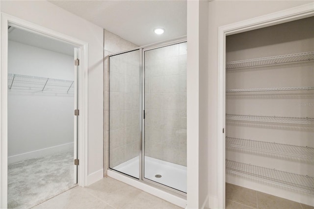 bathroom featuring tile patterned flooring and a shower with shower door