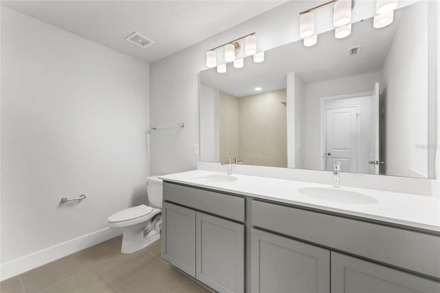 bathroom featuring tile patterned flooring, vanity, toilet, and walk in shower