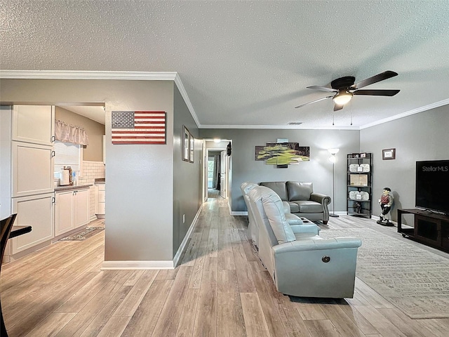 living room with a textured ceiling, light hardwood / wood-style floors, ceiling fan, and crown molding