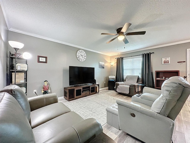 living room featuring ceiling fan, a textured ceiling, and ornamental molding