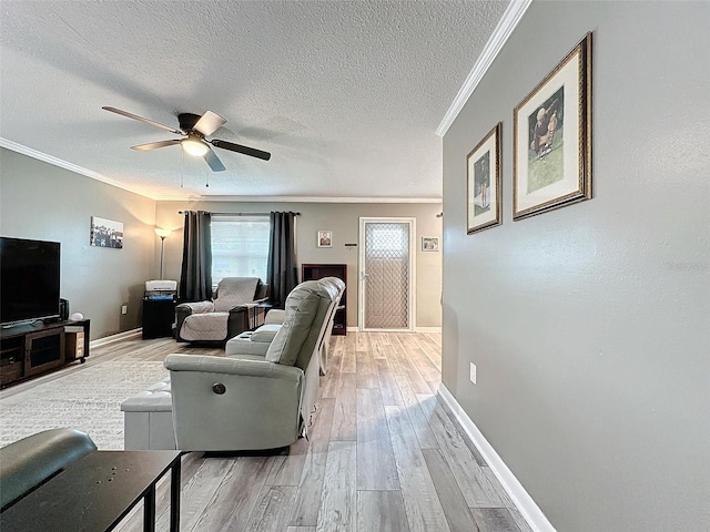 living room with ceiling fan, light hardwood / wood-style flooring, a textured ceiling, and ornamental molding