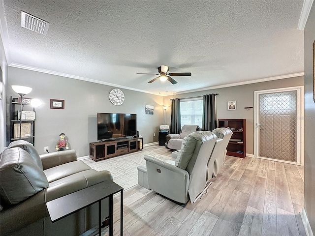 living room featuring a textured ceiling, light wood-type flooring, ceiling fan, and crown molding