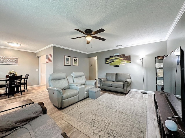 living room featuring a textured ceiling, light wood-type flooring, ceiling fan, and ornamental molding