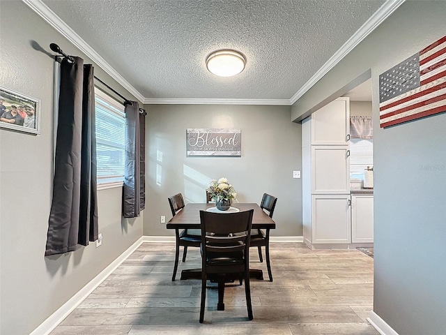 dining room featuring a textured ceiling, light hardwood / wood-style flooring, and crown molding