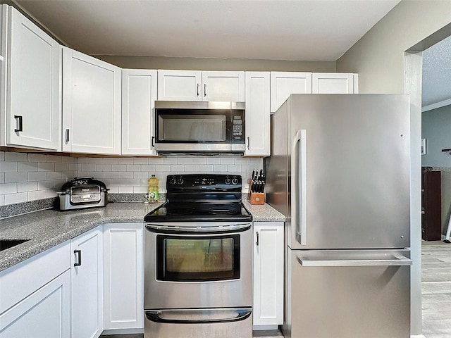 kitchen featuring backsplash, white cabinets, and appliances with stainless steel finishes