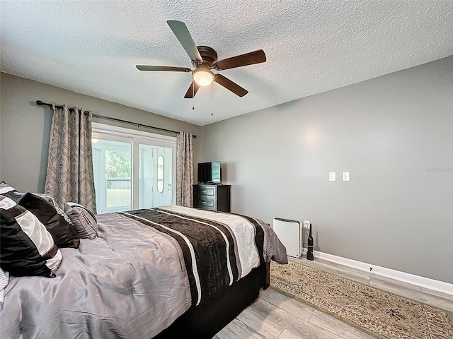 bedroom featuring a textured ceiling, light hardwood / wood-style flooring, and ceiling fan