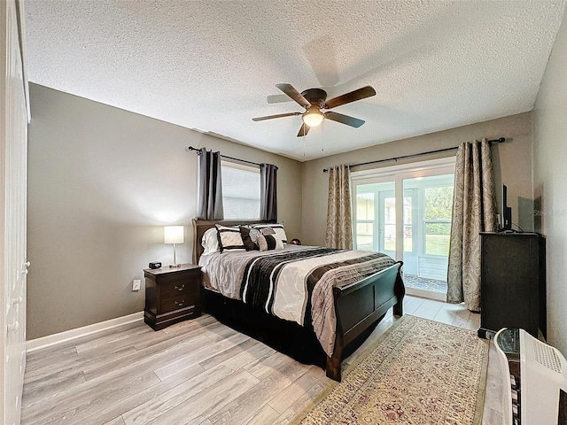 bedroom with ceiling fan, light wood-type flooring, a textured ceiling, and access to outside