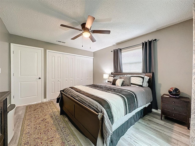 bedroom featuring wood-type flooring, a textured ceiling, and ceiling fan