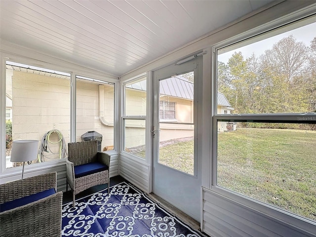 sunroom with wooden ceiling, a healthy amount of sunlight, and vaulted ceiling