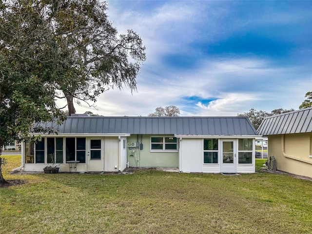 rear view of house featuring a lawn