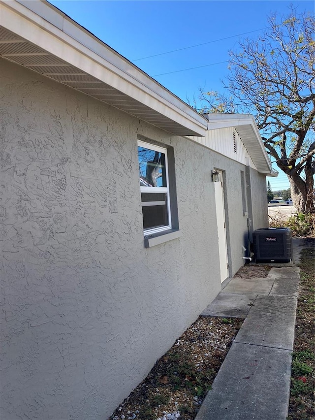 view of side of home with central AC